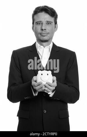 Portrait von gutaussehenden Geschäftsmann in Anzug halten Sparschwein Stockfoto