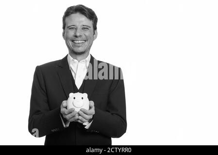 Portrait von glücklich gut aussehend Geschäftsmann in Anzug halten Sparschwein Stockfoto