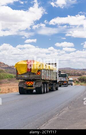 Ein großer Lastwagen, der auf der Mombasa Autobahn unterwegs ist und Waren transportiert, Kenia Stockfoto