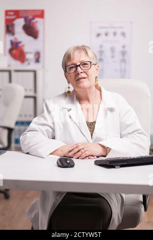 Reife weibliche Arzt in Klinik Schrank Blick auf Kamera. Stockfoto