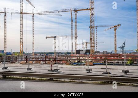 Auf einer großen Baustelle gibt es viele gelbe Baustellen Kraniche und der Himmel ist blau Stockfoto