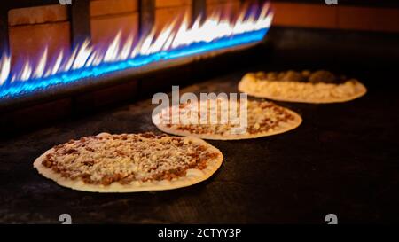 Hintergrundbild der Pizzaproduktion in einem heißen Ofen.Pizzaproduktion Stockfoto