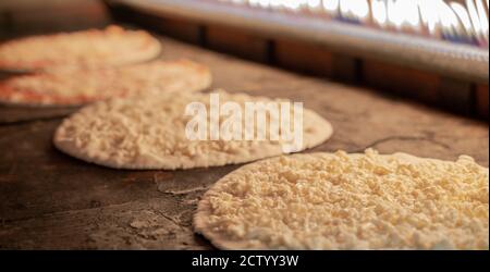 Hintergrundbild der Pizzaproduktion in einem heißen Ofen.Pizzaproduktion Stockfoto
