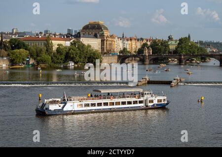PRAG, TSCHECHISCHE REPUBLIK: Sightseeing-Boot auf der Moldau mit Legionsbrücke und dem gewölbten Nationaltheater (Narodni divadlo) im Hintergrund Stockfoto