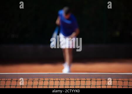 Tennisspieler, der sich für den ersten Aufschlag auf einem vorbereitet Sandspielplatz Stockfoto