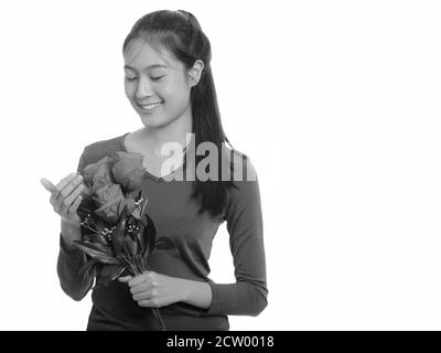 Junge glücklich Asiatischen Teenager Mädchen lächelnd mit roten Rosen zum Valentinstag bereit Stockfoto