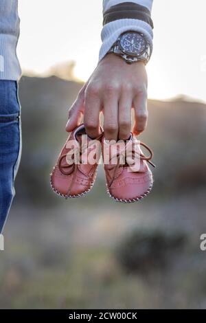 Mutterschaft Foto-Shooting, ein Vater hält die neuen Babys Schuhe in den Händen, Kapstadt, Südafrika Stockfoto