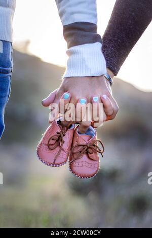 Mutterschaft Fotoshooting, ein Vater und Mutter halten die neuen Babys Schuhe in den Händen, Kapstadt, Südafrika Stockfoto