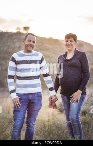 Mutterschaft Fotoshooting, ein Vater und Mutter halten die neuen Babys Schuhe in den Händen, Kapstadt, Südafrika Stockfoto