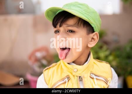 Cut kleinen Jungen Spaß, ragt aus seiner Zunge und macht lustig. Stockfoto