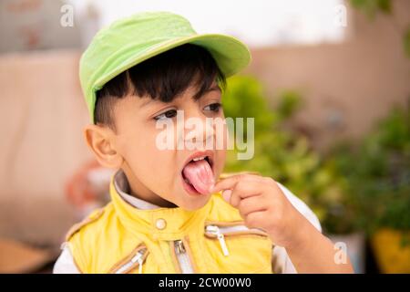 Cut kleinen Jungen Spaß, ragt aus seiner Zunge und macht lustig. Stockfoto