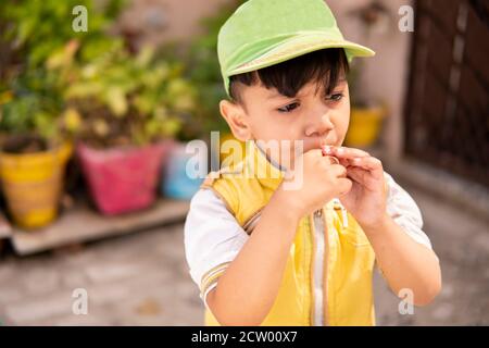 Schneiden Sie kleinen Jungen essen Lollipop Süßigkeiten und Spaß im Freien zu Tageszeiten. Stockfoto