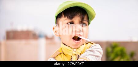 Schneiden Sie kleinen Jungen essen Lollipop Süßigkeiten und Spaß im Freien zu Tageszeiten. Stockfoto