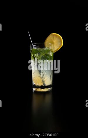 Kalte Limonade in einem Glas mit Eis auf einem schwarzen Hintergrund Stockfoto