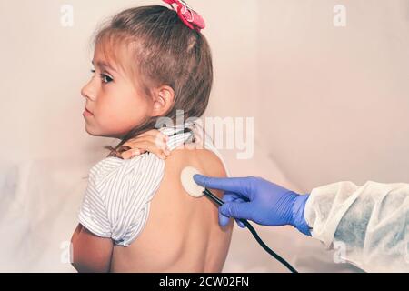 Der Arzt hört auf die Lungen eines kranken Mädchens im Krankenhaus. Kind bei einem Kinderarzt Termin. Definition der Krankheit. Ärztliche Untersuchung Stockfoto