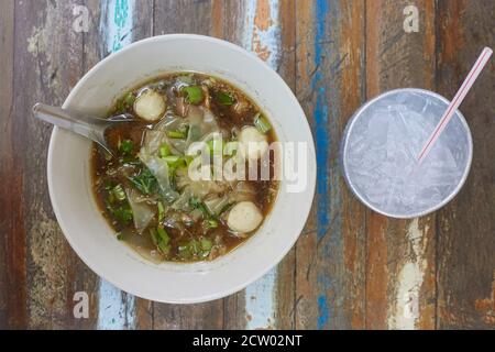 Reisnudeln Suppe mit Fleischball in einer Schüssel Essen von Essstäbchen, asiatische Lebensmittel, Thai-Stil, Ansicht von oben. Kaltes Wasser Stockfoto