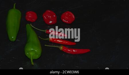 Schieferteller verschiedener Arten von roten und grünen Paprika wie Serenade, Chili, jalapeños, Chiles, Naga, Habanero, Scorpion Stockfoto