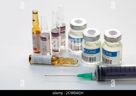 Hypodermische Spritzennadel mit Impfstoffflaschen und Injektionsfläschchen auf Weißer Hintergrund Stockfoto