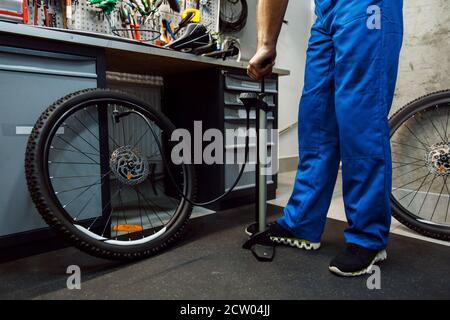 Fahrrad Montage in der Werkstatt, Mann bläst Rad Stockfoto