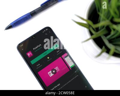 LOD, Israel - 8. Juli 2020: Moderner minimalistischer Büroarbeitsplatz mit schwarzem Smartphone mit Pink Park App Play Store Seite auf weißem Hintergrund. Bis Stockfoto