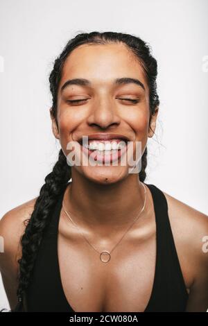 Nahaufnahme einer lächelnden Fitness-Frau. Portrait der Frau in Fitness tragen lächelnd mit geschlossenen Augen. Stockfoto