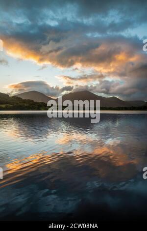 Atemberaubendes Landschaftsbild bei Sonnenaufgang mit Blick über Loweswater im See Bezirk in Richtung Low Fell und Grasmere mit bunten Himmel brechen Auf dem Berg Stockfoto