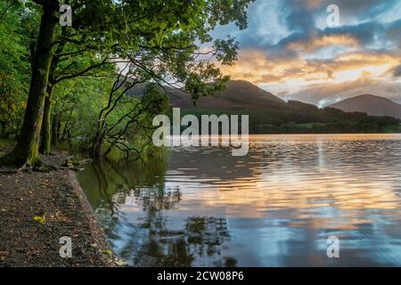 Atemberaubendes Landschaftsbild bei Sonnenaufgang mit Blick über Loweswater im See Bezirk in Richtung Low Fell und Grasmere mit bunten Himmel brechen Auf dem Berg Stockfoto