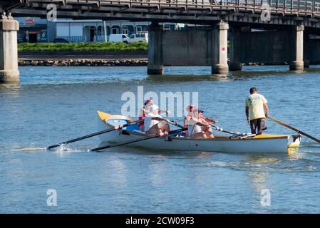 Eine Gruppe älterer Männer übt das Rudern in einem langen australischen Surfrettungsboot (Surfboot) auf dem Nambucca River in Macksville, New South Wales, Australien Stockfoto