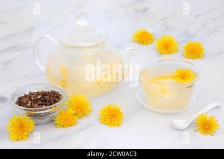 Immun stärkenden Löwenzahn Blume & Zitrone Tee in einem Glas Teekanne & Tasse mit getrockneten Löwenzahn Wurzel. Senkt Cholesterin, Blutdruck und reguliert Bloo Stockfoto