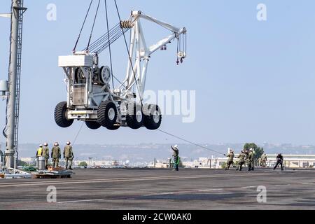 SAN DIEGO (Sept 16, 2020) – US Navy Segler an den Flugzeugträger USS Theodore Roosevelt (CVN 71) zugeordnet halten eine Sicherheitslinie, um das Schiff Flugzeugkran (Tilly), wie es auf das Schiff Flugdeck angehoben wird stabil 16. September 2020. Theodore Roosevelt ist in San Diego zuhause. (USA Navy Foto von Mass Communication Specialist 2nd Class Kyle Hafer) Stockfoto