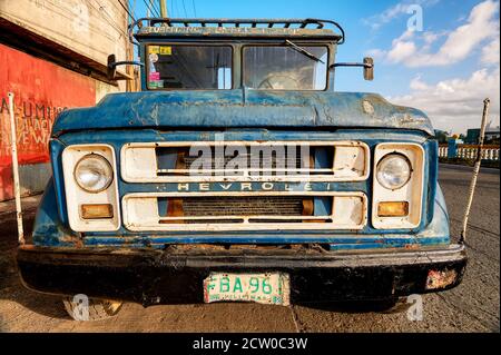 Frontansicht eines alten blauen rostigen Chevrolet-Lastwagens, der an einer Straße in Iloilo City, Philippinen, geparkt ist Stockfoto