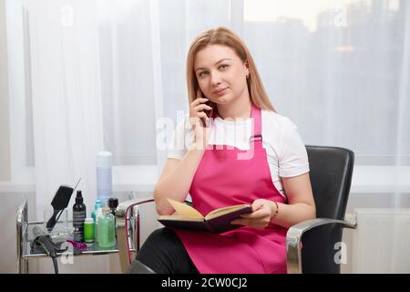Friseur im Gespräch mit einem Kunden am Telefon Termin Stockfoto