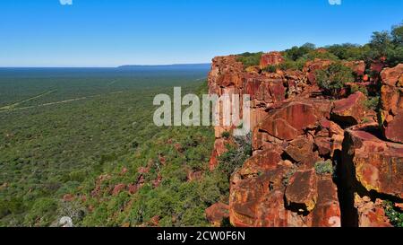 Panoramablick über die buschbedeckte Kalahari-Wüste bis zum Horizont vom Kamm der roten Felsen des Waterberg Plateau, Namibia, Afrika. Stockfoto