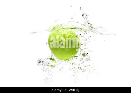 Ein grüner Apfel fällt in Wasser auf weißem Hintergrund mit Spritzern, Tropfen und Blasen. Stockfoto
