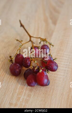 Vertikale Aufnahme eines Bükels roter Trauben auf Holz Stockfoto