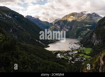 Geiranger Fjord vom Hang aus gesehen am Sommertag mit einem großen Kreuzfahrtschiff im Hafen, Norwegen Stockfoto