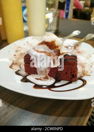 Eine klassische Kombination aus schmelzendem Vanilleeis auf dem doppelten Schokoladenbrownie. Stockfoto