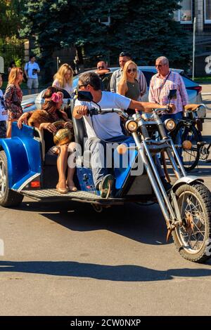 Kremenchug, Ukraine - 22. September 2018: Unbekannte fahren am Tag der Stadt Kremenchug mit einem dreirädrigen Motorrad auf einem Stadtplatz Stockfoto