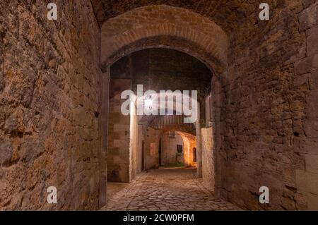 Schattiger Eingang in das riesige Schloss von Sedan, keine Leute, nachts unter Straßenlaternen Stockfoto