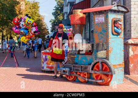 Kremenchug, Ukraine - 22. September 2018: Mann verkauft Zuckerwatte während des Sweet Kremenchug Festivals. Zuckerwatte Herstellung Prozess Stockfoto