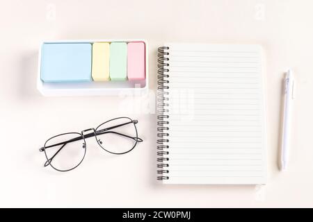 Nahaufnahme eines Notizblocks, eines Stiftes, einer Brille und Haftnotizen Stockfoto