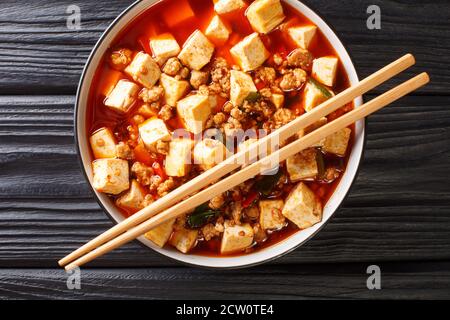 Zarte Mapo Tofu in einer aromatischen und würzigen Sauce gekocht, begleitet von Hackfleisch Nahaufnahme in der Platte auf dem Tisch. Horizontale Draufsicht von oben Stockfoto