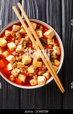 Authentische chinesische Stil mapo tofu ist eines der Branding-Gerichte der Szechuan Küche Nahaufnahme in der Platte auf dem Tisch. Vertikale Draufsicht von oben Stockfoto