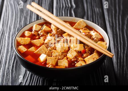 Chinesische Mapo Tofu wird gebraten Sichuan Schweinefleisch und Tofu in einer heißen Sauce close-up in einer Schüssel auf dem Tisch. Horizontal Stockfoto