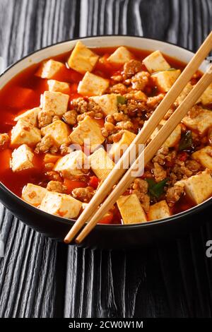 Authentische chinesische Stil mapo tofu ist eines der Branding-Gerichte der Szechuan Küche Nahaufnahme in der Platte auf dem Tisch. Vertikal Stockfoto