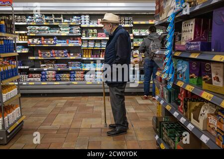 Ältere Paare, die während der Coronavirus-Pandemie in einem Londoner Supermarkt einkaufen, tragen obligatorische Gesichtsmasken, England, Großbritannien Stockfoto