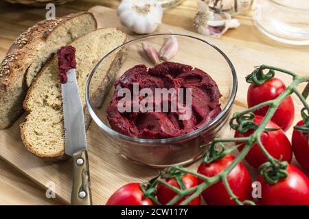 Sizilianische Produkte: Stillleben mit konzentrierter Tomatensauce namens "Astratto", Vollkornbrot, Piccadilly Tomaten und Knoblauch Stockfoto