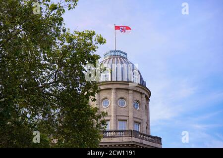 Nahaufnahme eines neoklassizistischen Gebäudes mit Rotunde im Geschäftsviertel Königsallee. Die Flagge des Landes Nordrhein-Westfalen ist an der Spitze. Stockfoto