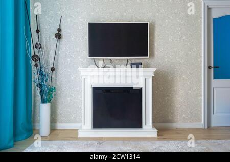 Modernes gemütliches Wohnzimmer mit TV und Dekor auf dem Boden Stockfoto
