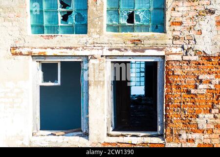 Grunge beschädigte kaputte Fenster in Backstein zerstörte Gebäudewand Stockfoto